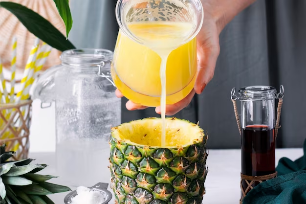 Pouring pineapple juice into a curved pineapple fruit.