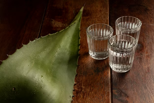 Three glasses of drink next to a plant