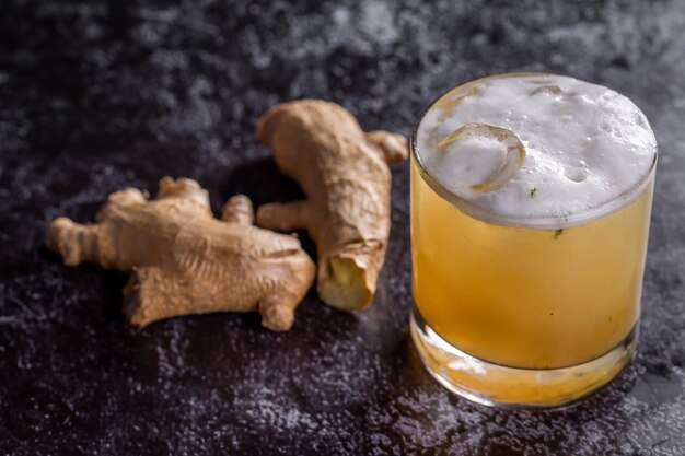 A glass of beer with real ginger on the side.